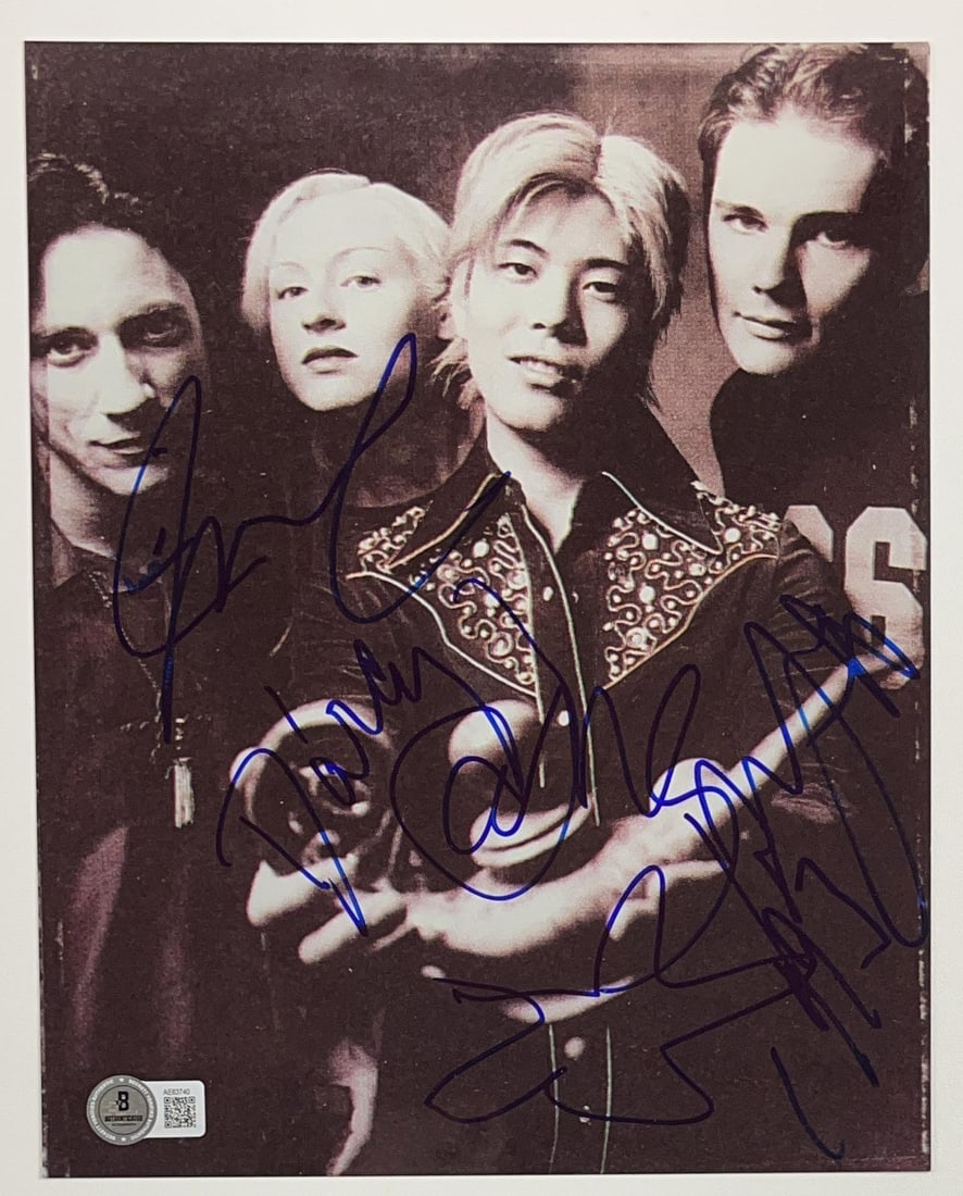 The Smashing Pumpkins Group Signed 10" x 8" Photo (4 Sigs) (Beckett Authentication): Scarce black-and-white 10" x 8" photo signed in blue felt tip marker by The Smashing Pumpkins band members D'arcy Wretzky, James Iha, Jimmy Chamberlain, and Billy Corgan. In fine condition.
