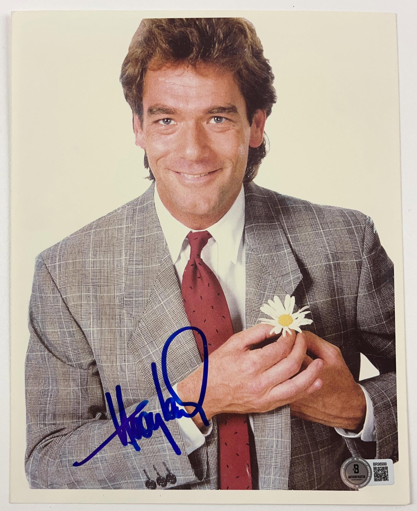 Huey Lewis Signed 10" x 8" Photo (Beckett Authentication): Color 10" x 8" photo signed in blue felt tip marker by musician Huey Lewis. In fine condition. Authenticated by Beckett, with their official hologram affixed to the front bottom right corner