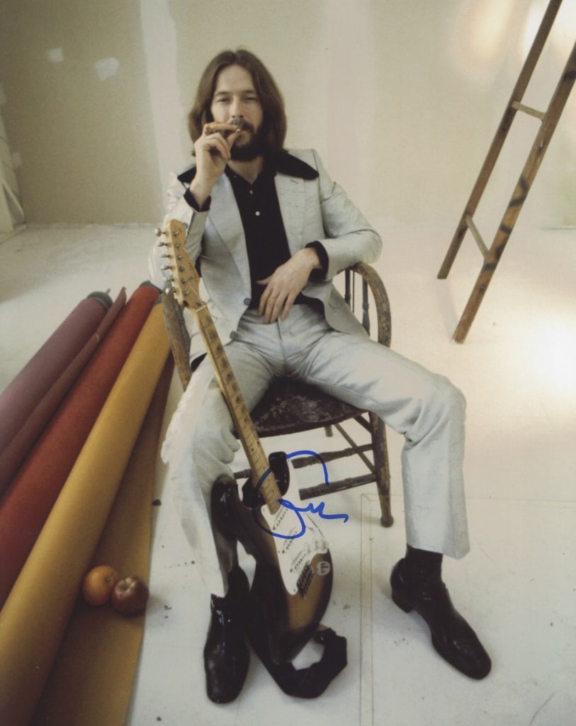Eric Clapton Signed 14" x 11" Photo (ACOA Authentication): Color 14" x 11" photo signed in blue felt tip marker by musician Eric Clapton. In fine condition. Accompanied by an ACOA COA (#SA58647). Obtained in-person. Photographed by Barry Feinstein in a Los