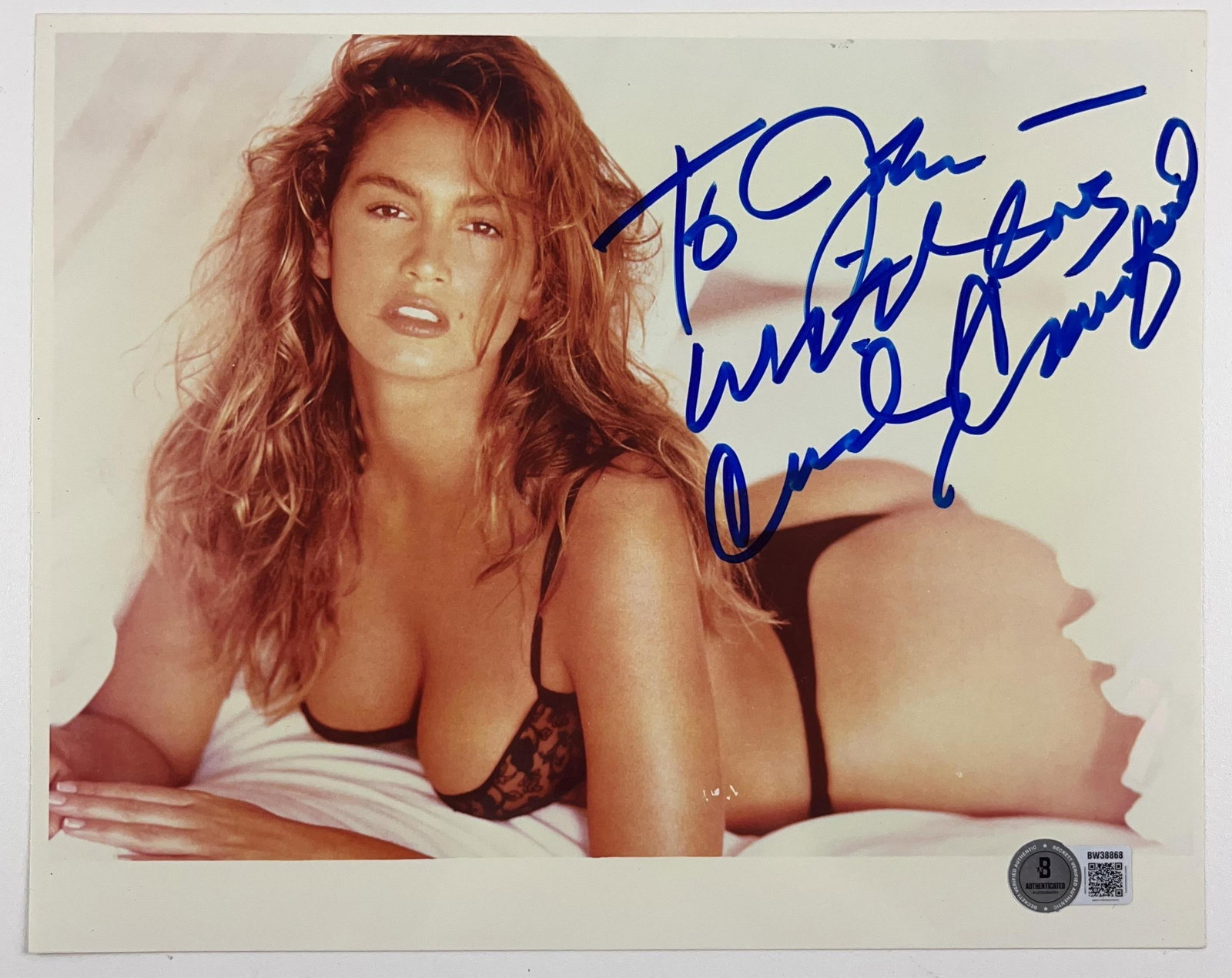 Cindy Crawford Signed 8" x 10" Photo (Beckett Authentication): Color 8" x 10" photo signed in blue felt tip marker by model Cindy Crawford, who inscribed the message "To John with love" before her signature. In fine condition. Authenticated by Beckett, with