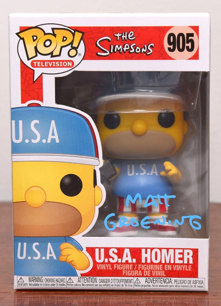 Matt Groening Signed "The Simpsons" Homer Simpson Funko Pop #905 (Beckett Authentication): "The Simpsons" Homer Simpson Funko Pop #905 signed on the front plastic window in blue felt tip marker by animator Matt Groening. Measuring approximately 6.25" x 4.5" x 3.5" and in fine condition.