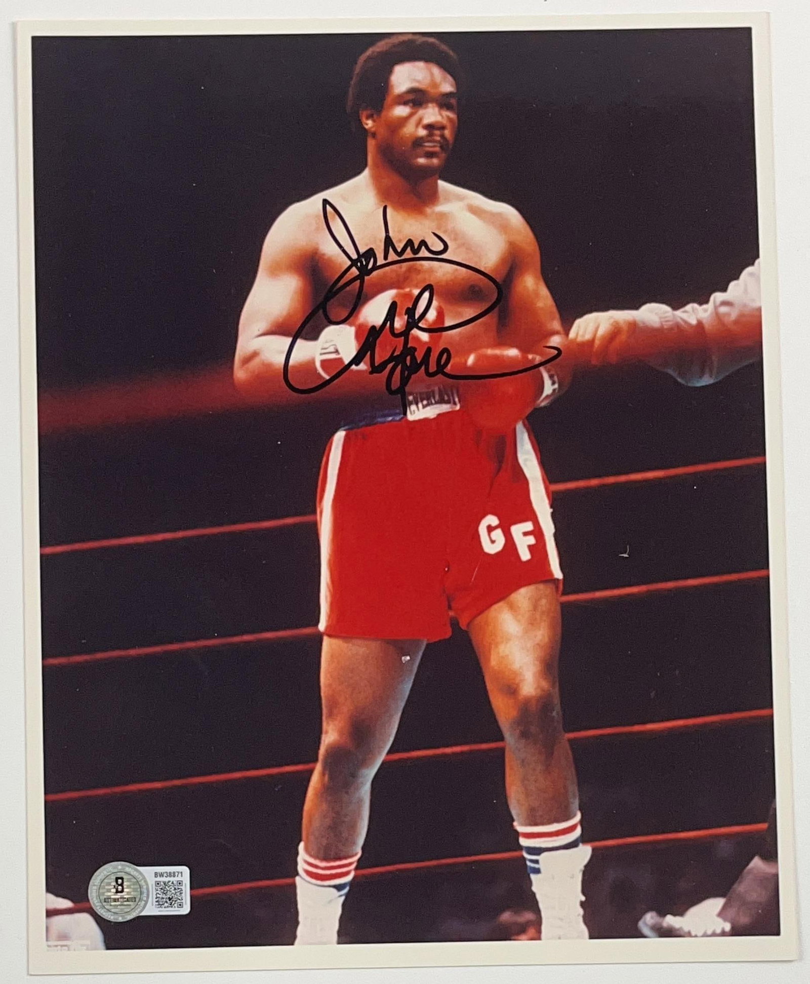 George Forman Signed 10" x 8" Photo (Beckett Authentication): Color 10" x 8" photo signed in black felt tip marker by boxer George Forman, who inscribed "To John" before his signature. In fine condition. Authenticated by Beckett, with their official hologram