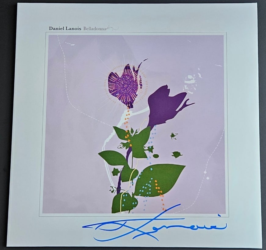 Daniel Lanois Signed "Belladonna" Album (Third Party Guaranteed): "Belladonna" album signed on the cover in blue felt tip marker by musician Daniel Lanois. Measuring approximately 12" x 12" and in fine condition. Record is included. Provenance Eaton & Brennan Auctio