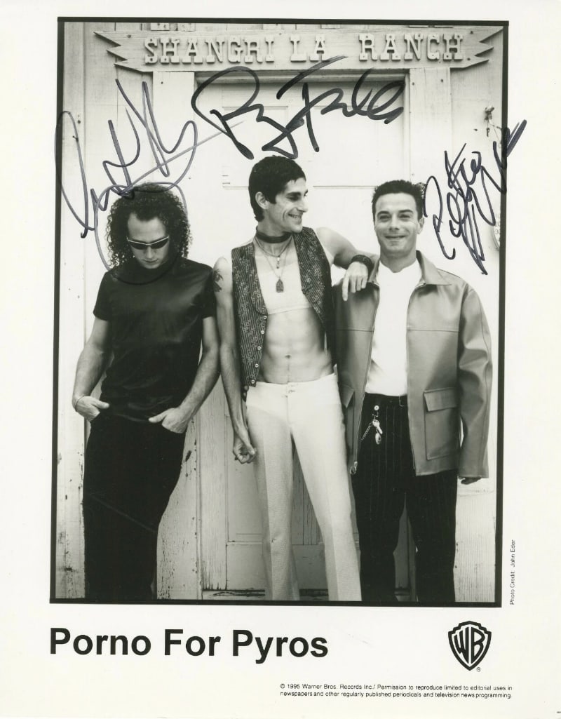 Porno for Pyros Group Signed 10" x 8" Promo Photo (3 Sigs) (ACOA): Black-and-white 10" x 8" promotional photo signed in black felt tip marker by Porno for Pyros band members Stephen Perkins, Perry Farrell, and Peter Distefano. In fine condition. Accompanied by an ACO