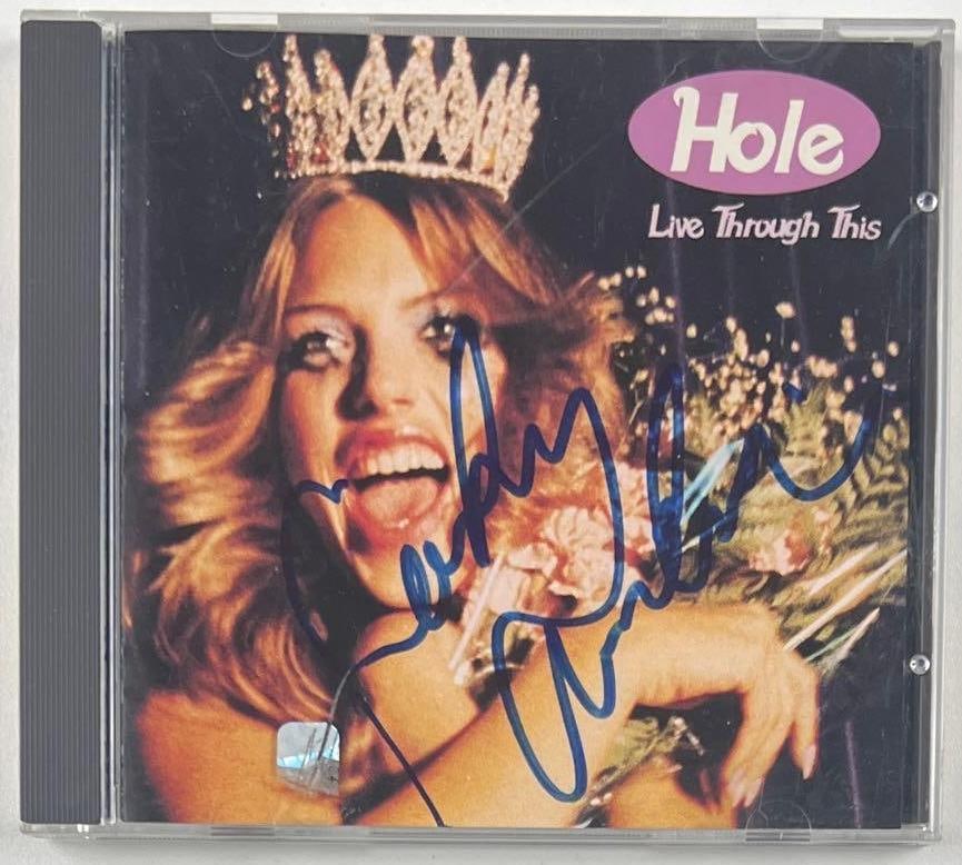 Hole: Courtney Love Signed "Live Through You" CD (Beckett Authentication): "Live Through You" CD signed on the cover in blue felt tip marker by Hole front woman Courtney Love. Measuring approximately 5" x 5" and in fine condition. CD is included. Obtained in-person.