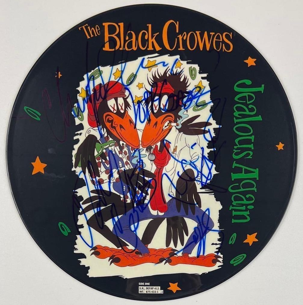 The Black Crowes Group Signed "Jealous Again" Picture Disc (5 Sigs) (Beckett): "Jealous Again" album picture disc signed on the front in blue felt tip marker by The Black Crowes band members Chris Robinson, Rich Robinson, Johnny Colt, Steve Gorman, and Jeff Cease. Measuring