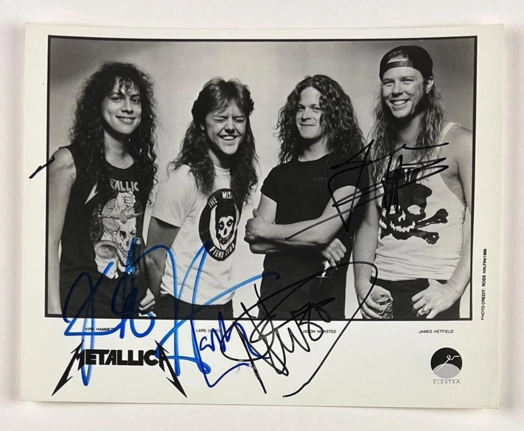 Metallica Group Signed 8" x 10" Promo Photo (4 Sigs) (Beckett Authentication): Awesome black-and-white 8" x 10" promotional photo signed in black and blue felt tip markers by Metallica band members James Hetfield, Lars Ulrich, Kirk Hammett, and Jason Newsted. In fine condition. 