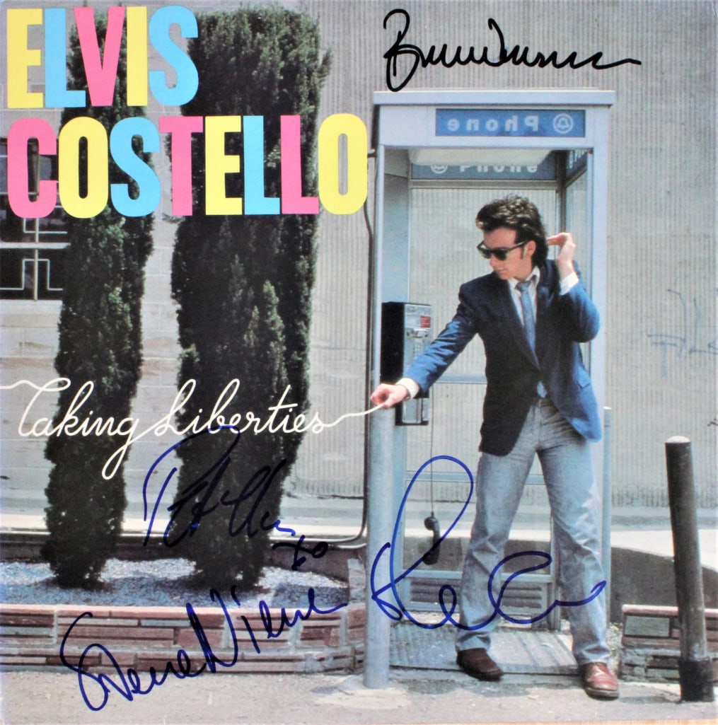 Elvis Costello & the Attractions Group Signed "Taking Liberties" Album (4 Sigs) (ACOA): "Taking Liberties" album signed on the cover in black and blue felt tip markers by Elvis Costello & the Attractions band members Elvis Costello, Pete Thomas, Steve Nieve, and Bruce Thomas. Measuring a