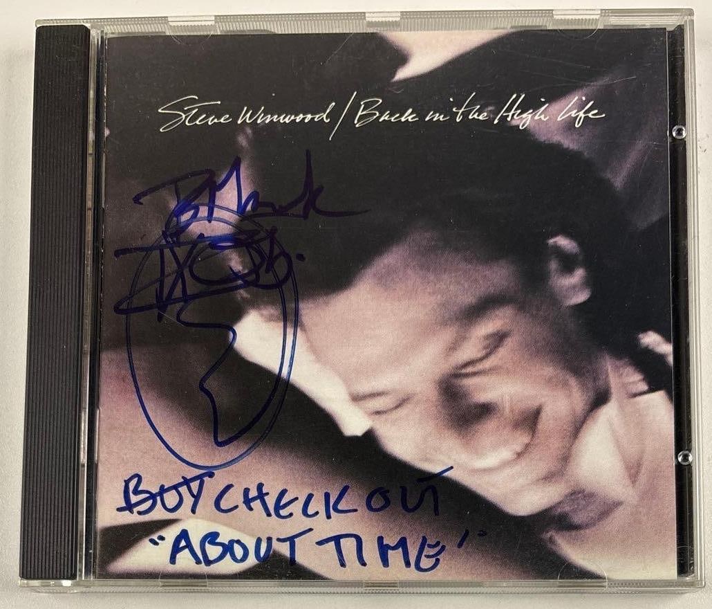 Steve Winwood Signed "Back in the High Life" CD (Third Party Guaranteed): "Back in the High Life" CD signed on the cover in blue felt tip marker by musician Steve Winwood, who also inscribed "Boy check out "About Time"" after his signature. Measuring approximately 5" x 5" a