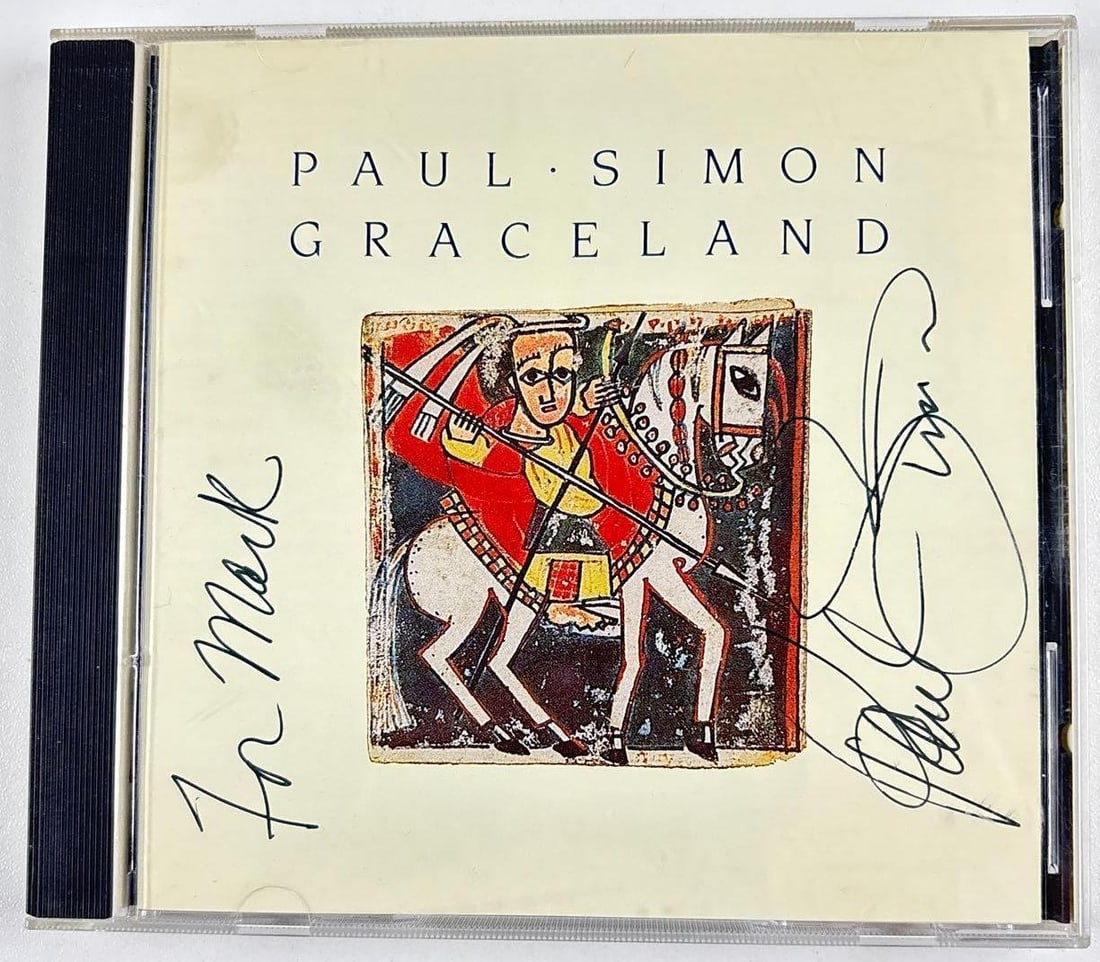 Paul Simon Signed "Graceland" CD (Third Party Guaranteed): "Graceland" CD signed on the cover in black ballpoint pen by musician Paul Simon, who inscribed "To Mark" before his signature. Measuring approximately 5" x 5" and in fine condition. CD is included. P