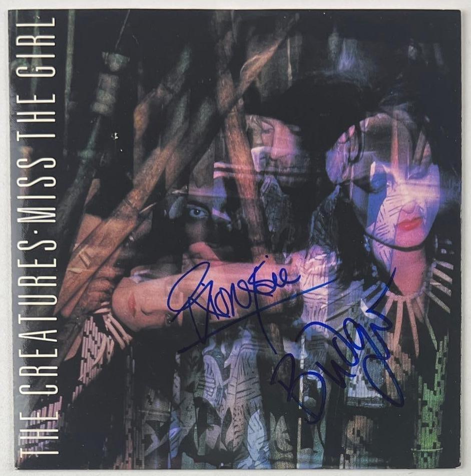 Siouxsie & the Banshees: Siouxsie Sioux & Budgie Signed "The Creatures Miss the Girl" 45 (2 Sigs): "The Creatures Miss the Girl" 45 signed on the cover in blue felt tip marker by Siouxsie & the Banshees band members Siouxsie Sioux and Budgie. Measuring approximately 7" x 7" and in fine condition. R