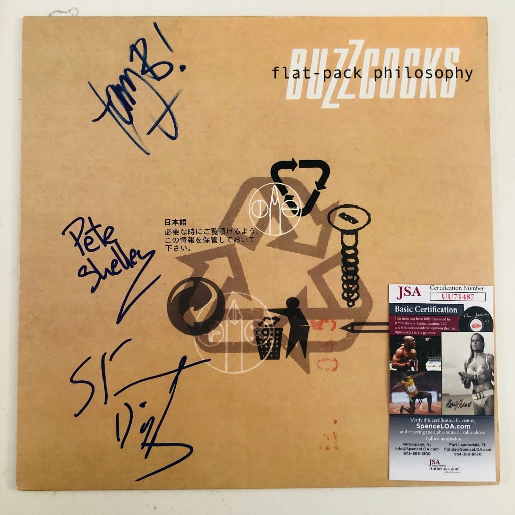 Buzzcocks Group Signed "Flat-Pack" Album (3 Sigs) (JSA Authentication): "Flat-Pack" album signed on the cover in blue felt tip marker by Buzzcocks band members Pete Shelley, Steve Diggle, and Tony Barber. Measuring approximately 12" x 12" and in fine condition. Record is 