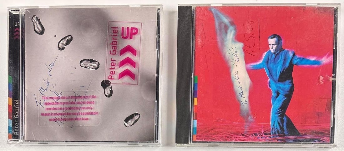 Peter Gabriel Signed (2) CD Lot: "Up" & "Us" CDs (Third Party Guaranteed): Lot of two signed CDs. "Up" CD signed on the cover in black ballpoint pen by musician Peter Gabriel, who also inscribed "To Mark and Lisa hello" before his signature. Measuring 5" x 5" and in fine