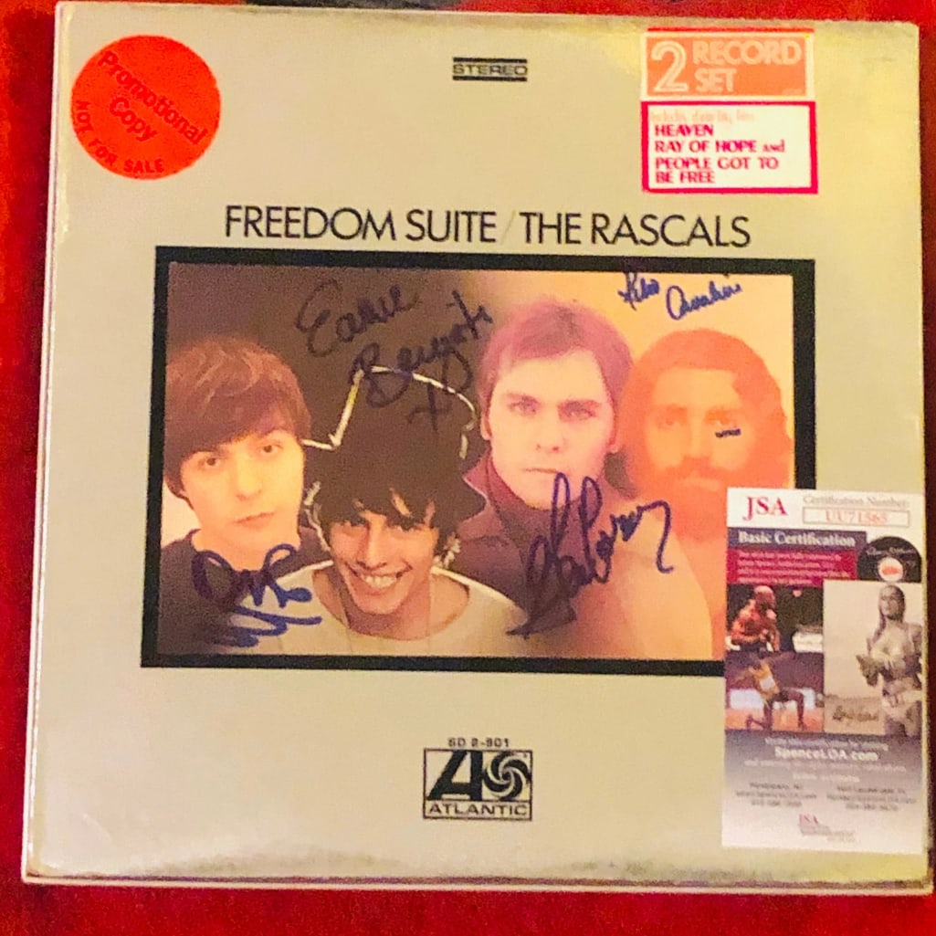 The Rascals Fully Group Signed "Freedom Suite" Album (4 Sigs) (JSA Authentication): "Freedom Suite" album signed on the cover in blue felt tip marker by The Rascals band members Felix Cavaliere, Eddie Brigati, Dino Danelli, and Gene Cornish. Measuring approximately 12" x 12" and in f
