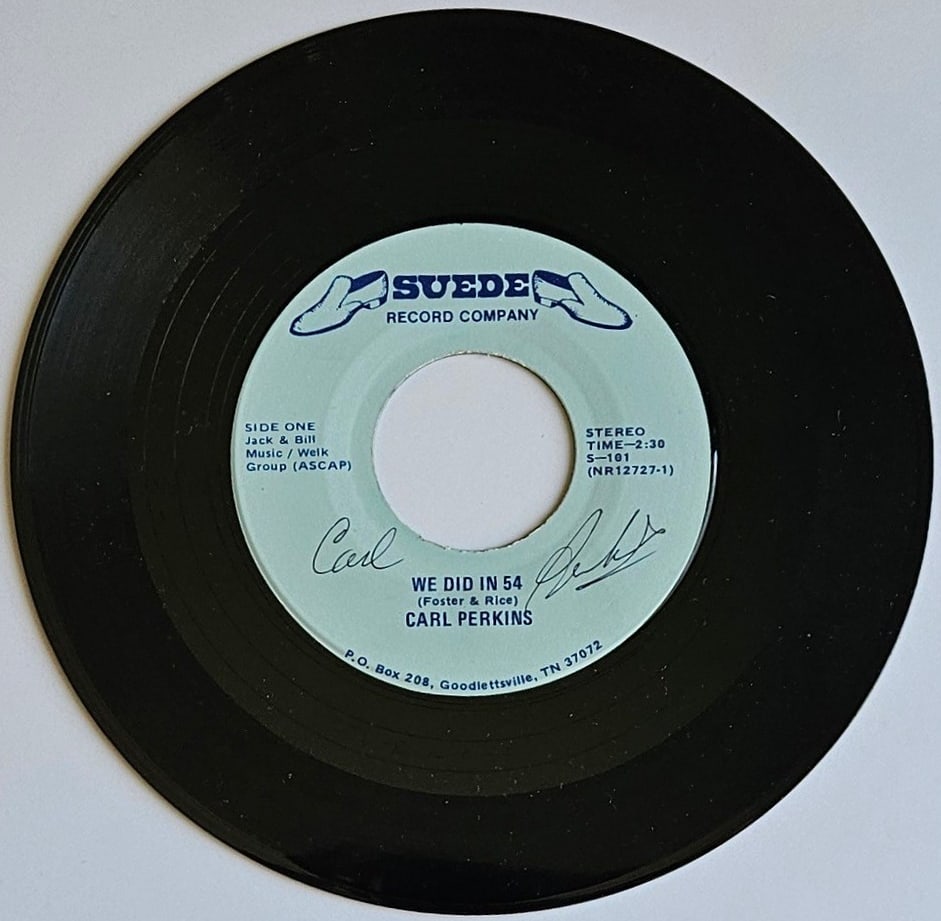 Carl Perkins Signed "We Did in 54" 45 (Third Party Guaranteed): "We Did in 54" 45 signed on the record disc front in black ballpoint pen by musician Carl Perkins. Measuring approximately 7" x 7" and in fine condition. Provenance Eaton & Brennan Auctions