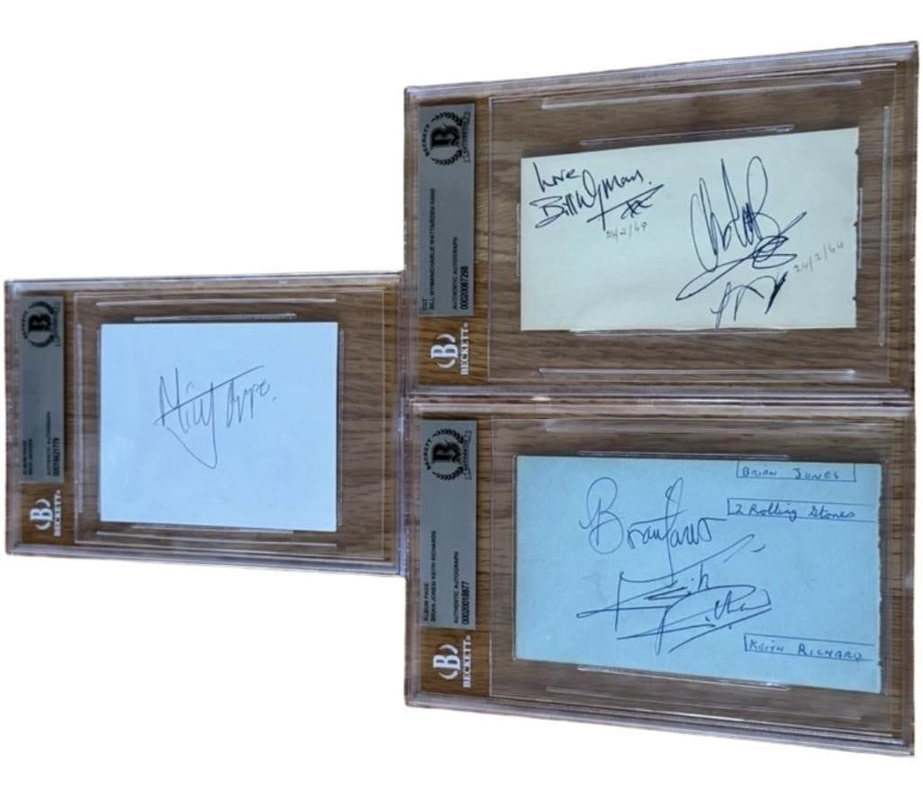 The Rolling Stones Fully Group Signed Set of (3) Album Pages (5 Sigs) (Beckett Encapsulated): Crisp set of (3) signed album pages by The Rolling Stones. The first album page is signed in blue ballpoint pen by Brian Jones and Keith Richards, with each signer’s printed name appearing besid