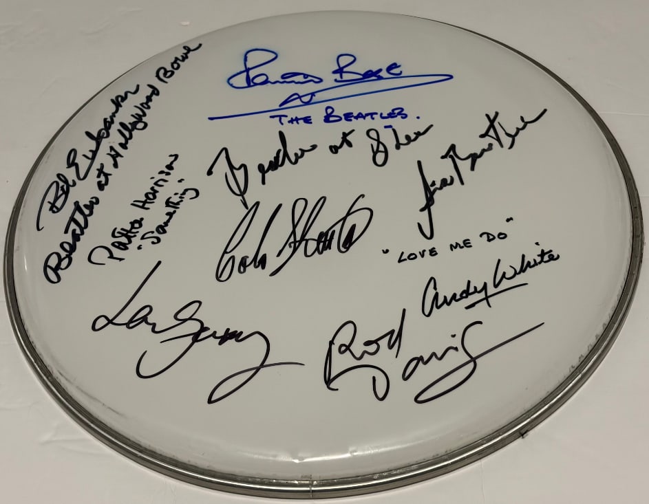The Beatles & Quarrymen Signed 12" Drumhead (7 Sigs) (Third Party Guaranteed): White 12" drumhead signed in black and blue felt tip markers by The Quarrymen band members Rod Davis, Colin Hanton, Len Garry, and former Beatles members Pete Best, who inscribed "The Beatles" after h