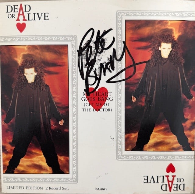 Dead or Alive: Pete Burns & Steve Coy Signed "My Heart Goes Bang" 45 (2 Sigs): "My Heart Goes Bang" 45 signed on the cover in black felt tip marker by Dead or Alive band members Pete Burns and Steve Coy. Measuring approximately 7" x 7" and in fine condition. Record is included. 