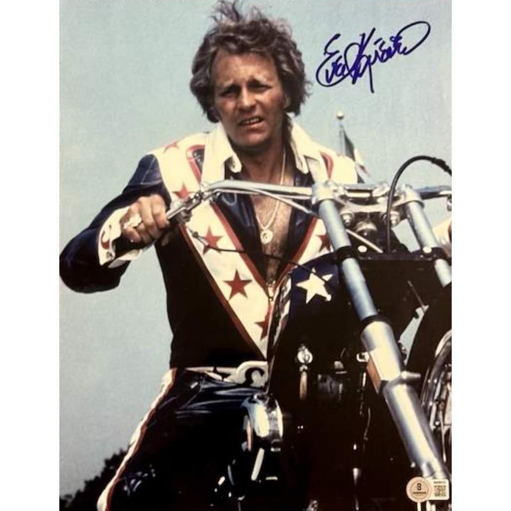 Evil Knievel Signed 14" x 11" Photo (Beckett Authentication): Color 14" x 11" photo signed in blue felt tip marker by racer Evil Knievel. In fine condition. Authenticated by Beckett, with their official hologram affixed to the front bottom right corner