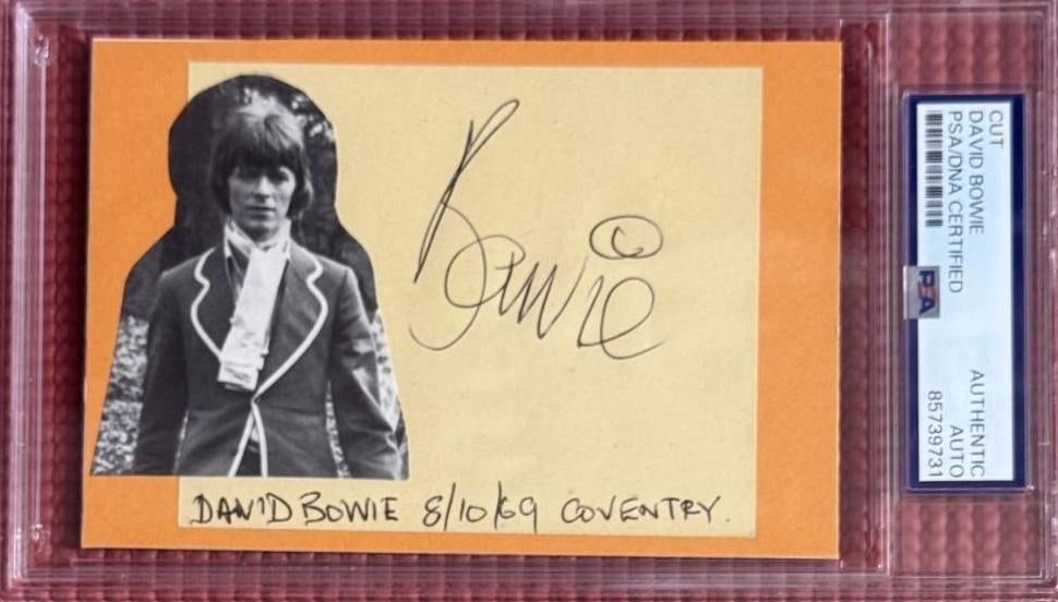 David Bowie Signed 3.5" x 5.5" 1969 Coventry Cut (PSA/DNA Encapsulated): Color 3.5" x 5.5" cut signed in black ballpoint pen by musician David Bowie. Underneath his signature is the date and location inscribed in black ballpoint pen "8/10/69 Coventry." In fine condition.