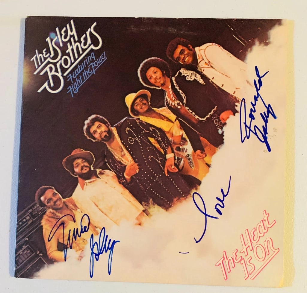 The Isley Brothers Group Signed "The Heat is On" Album (2 Sigs) (Beckett Authentication): "The Heat is On" album signed on the cover in blue felt tip marker by The Isley Brothers Ronald and Ernie Isley. Measuring approximately 12" x 12" and in fine condition. Record is included. Obtained