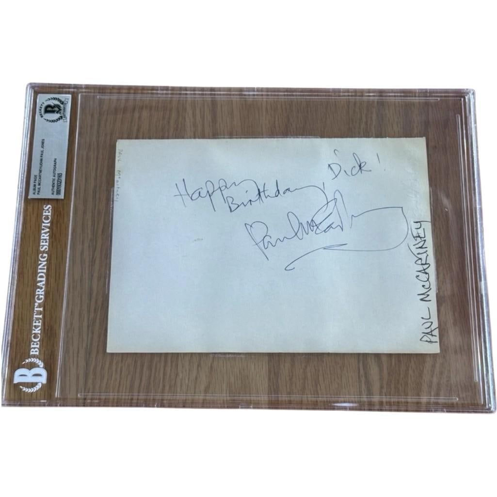 The Beatles & Led Zeppelin: Paul McCartney & John Paul Jones Signed 8" x 6" Album Page (Beckett): White 8" x 6" album page signed on both sides in black ballpoint pen by the Beatles band member Paul McCartney, who inscribed "Happy birthday Dick!" on one side, and musician John Paul Jones, who insc
