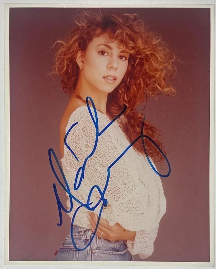 Mariah Carey Signed 10" x 8" Photo (Beckett Authentication): Color 10" x 8" photo signed in blue felt tip marker by musician Mariah Carey. In fine condition. Accompanied by a full Letter of Authenticity from Beckett (#YY56620).