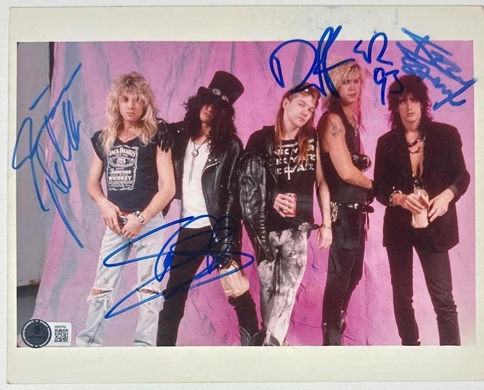 Guns N' Roses Group Signed 8" x 10" Photo (4 Sigs) (Beckett Authentication): Color 8" x 10" Guns N' Roses photo signed in blue felt-tip marker by band members Slash, Duff McKagan, who added the date "93" after his signature, Izzy Stradlin, and Steven Adler. In fine condition.