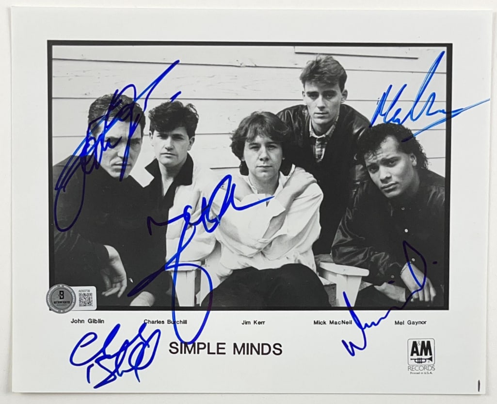 Simple Minds Group Signed 8" x 10" Promo Photo (5 Sigs) (Beckett Authentication): Black-and-white 8" x 10" promotional photo signed in blue felt tip marker by Simple Minds band members John Giblin, Charles Burchill, Jim Kerr, Mick MacNeil, and Mel Gaynor. In fine