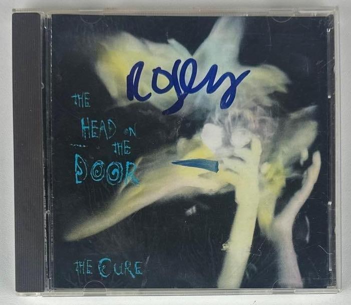 The Cure: Robert Smith Signed "The Head on the Door" CD (Beckett Authentication): "The Head on the Door" CD signed on the cover in blue felt tip marker by The Cure frontman Robert Smith. Measuring approximately 5" x 5" and in fine condition. CD is included. Accompanied by a Beckett