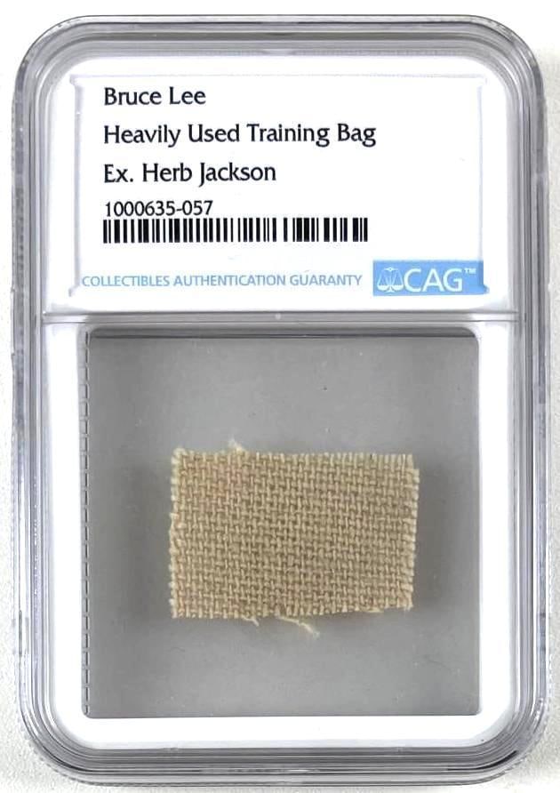 Bruce Lee Swatch from Personally Used Jeet Kune Do Training Bag (CAG Encapsulated): White 1" x 1" swatch of canvas from actor and martial artist Bruce Lee from his personally used Jeet Kune Do training bag. In fine condition. Encapsulated and authenticated by CAG (#1000635-057).