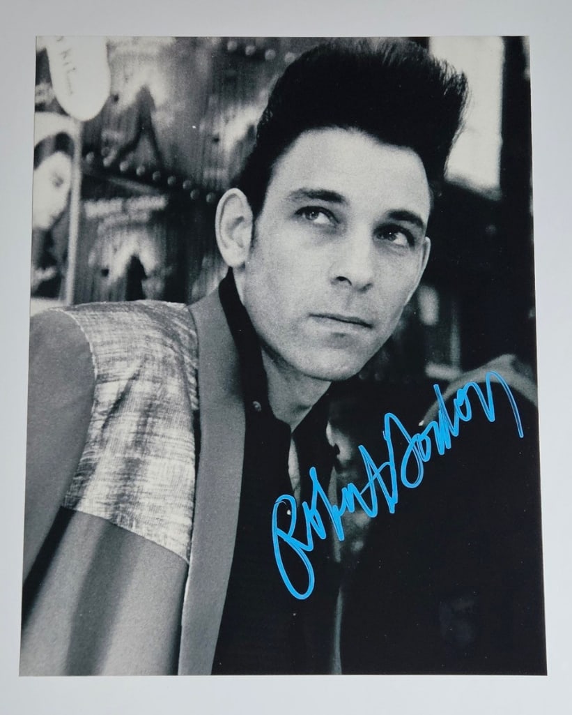 Robert Gordon Signed 14" x 11" Photo (Third party Guaranteed): Black-and-white 14" x 11" photo signed in blue paint pen by musician Robert Gordon. In fine condition. Provenance Eaton & Brennan Auctions guarantees this lot to pass Third-Party Authentication.