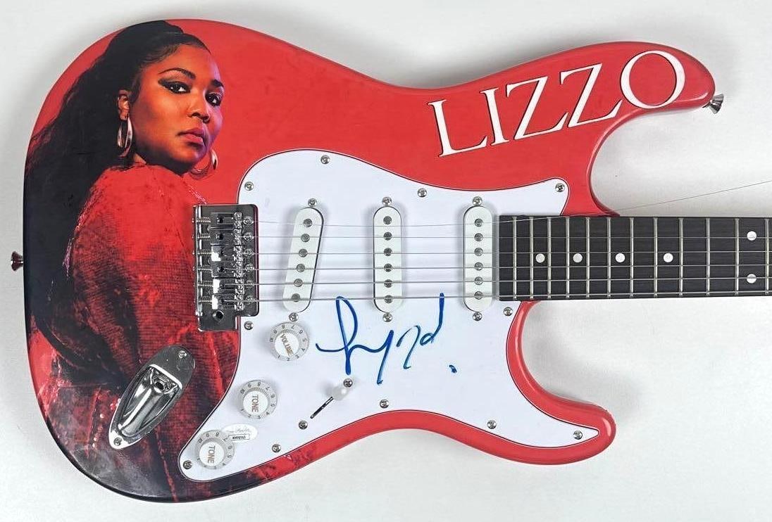 Lizzo Graphics Glarry Brand Stratocaster-Style Guitar (JSA Authentication): Lizzo graphics Glarry brand Stratocaster-style guitar signed on the pickguard in blue felt tip marker by musician Lizzo. Measuring approximately 38.5" x 12.75" and in fine condition. Authenticated by