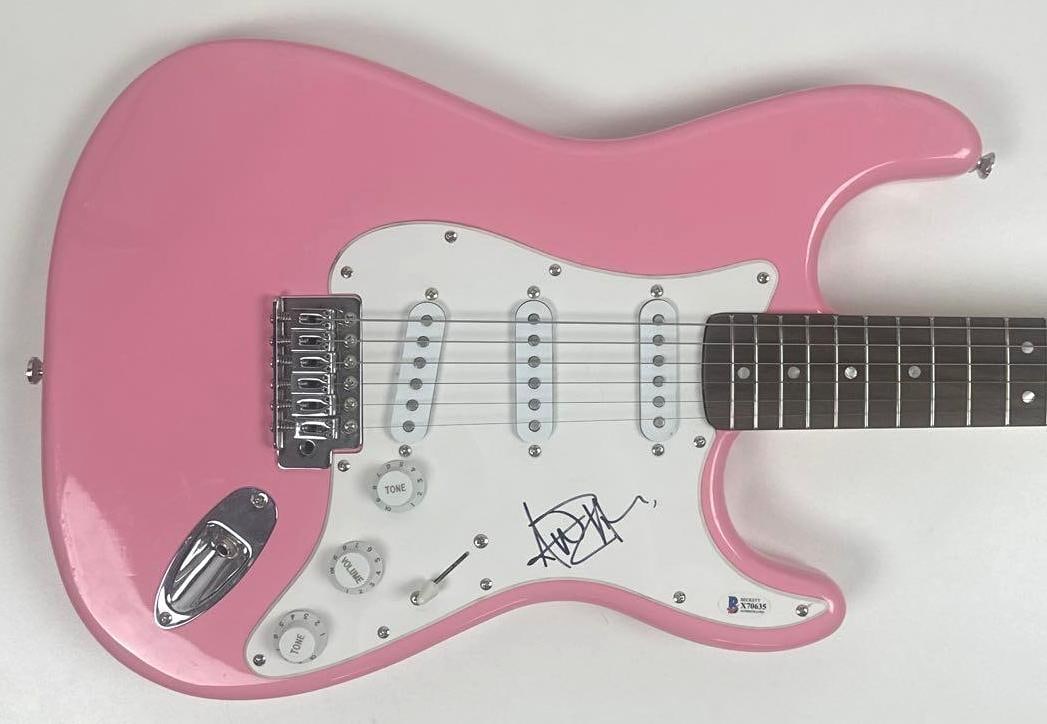 Avril Levine Signed Fender Squier Bullet Stratocaster-Style Guitar (Beckett): Pink Fender Squier Bullet Stratocaster-style guitar signed on the pickguard in black felt tip marker by musician Avril Levine. Measuring approximately 38.5" x 12.75" and in fine condition. Authenticat