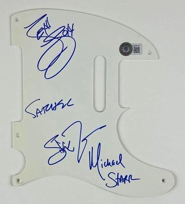 Steel Panther Group Signed Telecaster-Style Pickguard (4 Sigs) (Beckett): White 8.5" x 7.5" Telecaster-style pickguard signed on the front in blue felt tip marker by Steel Panther band members Michael Starr, Stix Zadinia, Lexxi Foxx and Satchel. In fine condition.