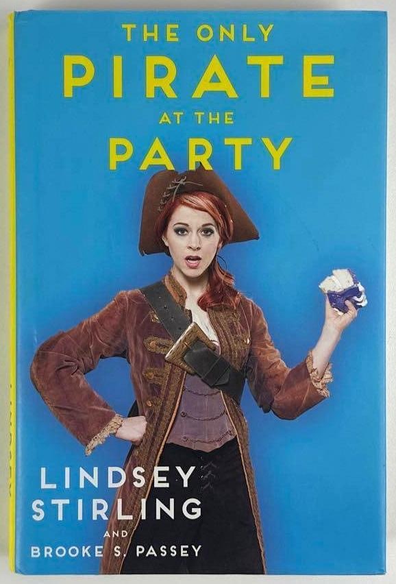 Lindsey Stirling Signed "The Only Pirate at the Party" Book (JSA Authentication): Color hardcover 9.25" x 6.25" "The Only Pirate at the Party" book signed on the inside front page in black ballpoint pen by musician Lindsey Stirling. In fine condition. Accompanied by a JSA COA (#AZ1