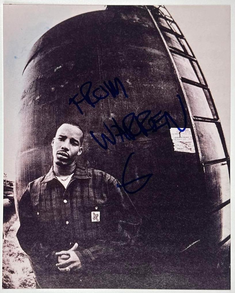 Warren G Signed 10" x 8" Photo (Third Party Guaranteed): Black-and-white 10" x 8" photo signed in blue felt tip marker by musician Warren G who signed "From Warren G." In fine condition. Provenance Eaton & Brennan Auctions guarantees this lot to pass
