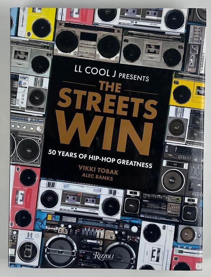 LL Cool J. Signed "The Streets Win: 50 Years of Hip-Hop Greatness" Book (Beckett Authentication): Color hardcover 12.75" x 9.5" book signed on the inside front page in white paint pen by musician LL Cool J. In fine condition. Authenticated by Beckett, with their official hologram affixed to the in