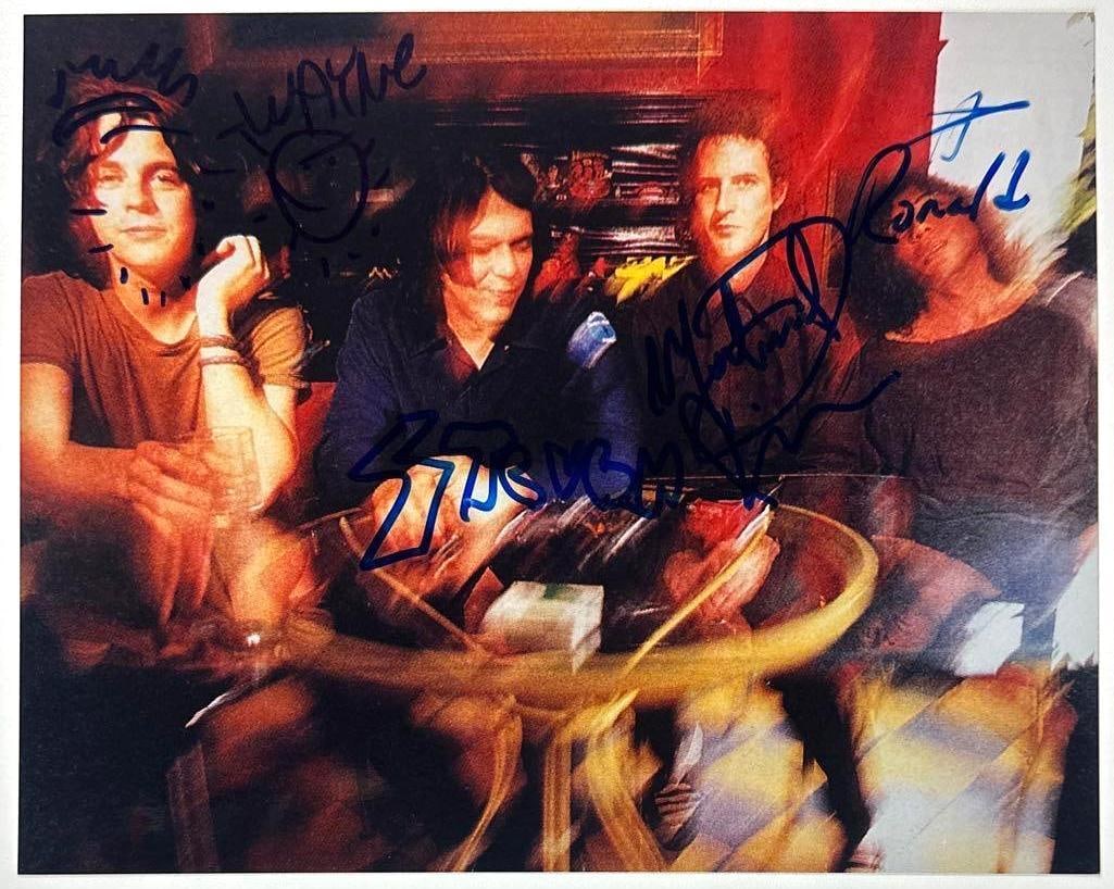 The Flaming Lips Group Signed 8" x 10" Photo (4 Sigs) (JSA Authentication): Color 8" x 10" photo signed in blue felt tip marker by the Flaming Lips band members Wayne Coye, who inscribed several doodles around his signature, Ronald Jones, Steven Drozd, who signed his name in