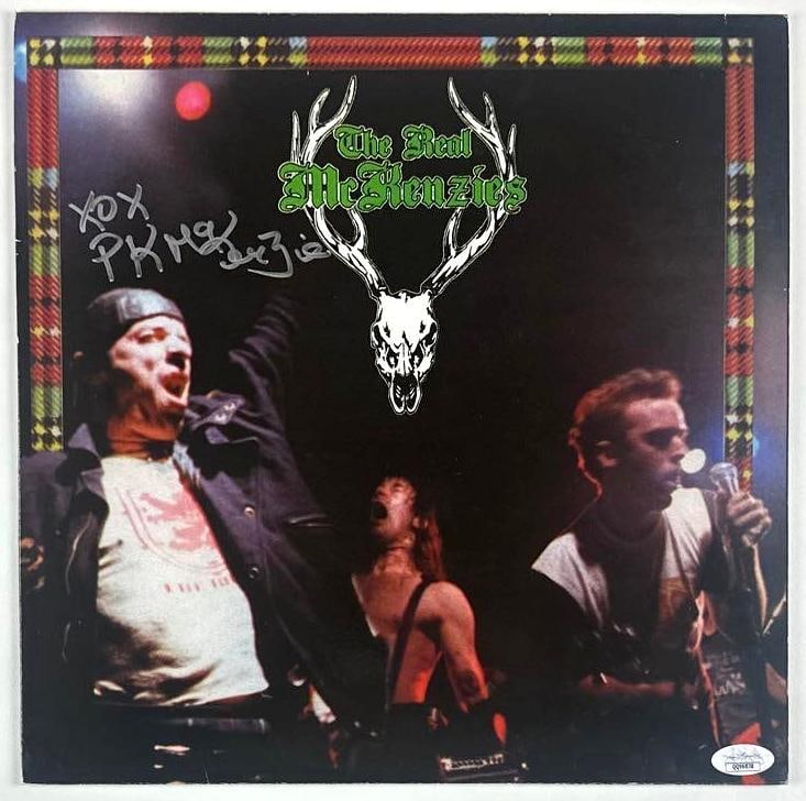 Paul McKenzie Signed The Real McKenzies Self-Titled Album (JSA Authentication): "The Real McKenzies" album signed on the cover in silver marker by frontman Paul McKenzie ("XOX PK McKenzie"). Measuring approximately 12" x 12" and in good condition with minor corner wear and edge