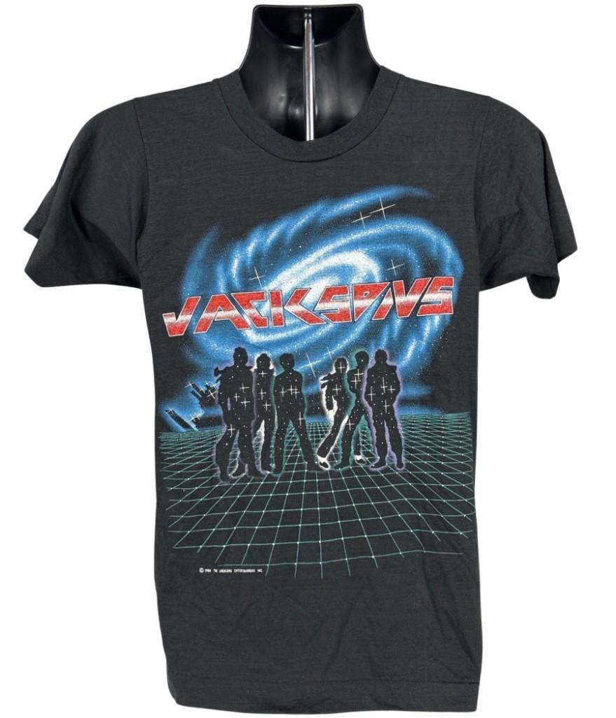 The Jacksons Vintage 1984 "Victory" Concert T-Shirt (Chip Rachlin Collection): Original 1984 Screen Stars brand black, white, red, and blue size mens small 25" x 16" t-shirt. The front shows an illustration of all five members as black silhouettes performing on a white grid
