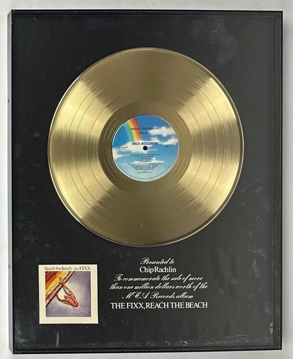 The Fixx "Reach the Beach" RIAA Certified Sales Award Presented to Chip Rachlin: RIAA Certified Sales Award presented to Chip Rachlin to commemorate the sale of more than $1,000,000 worth of the MCA Records album "Reach the Beach" by The Fixx. The vintage white matte framed displa