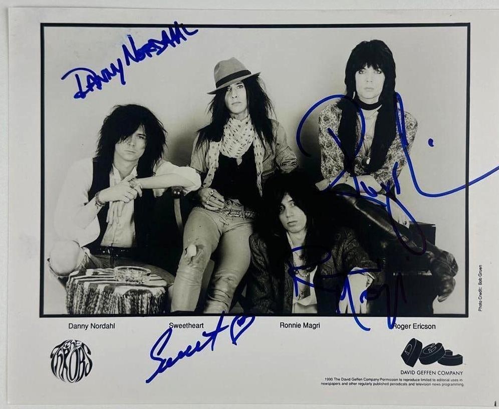 The Throbs Group Signed 8" x 10" Promo Photo (JSA Authentication): Black-and-white 8" x 10" promotional photo signed in blue felt tip marker by The Throbs band members Ronnie Sweetheart, Danny Nordahl, Ronnie Magri, and Roger Ericson. In fine condition.