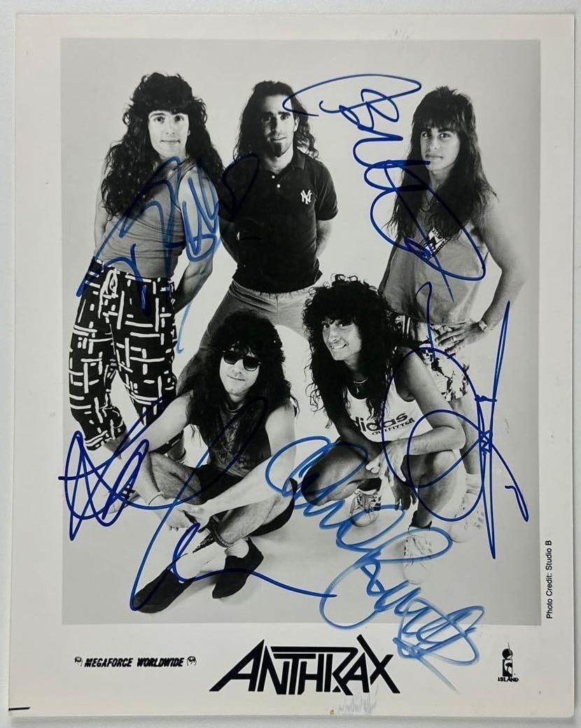 Anthrax Group Signed 10" x 8" Promo Photo (5 Sigs) (JSA Authentication): Black-and-white 10" x 8" promotional photo signed in blue felt tip marker by Anthrax band members Frank Bello, Scott Ian, Charlie Benante, Joey Belladonna, and Jon Donais. In fine condition.