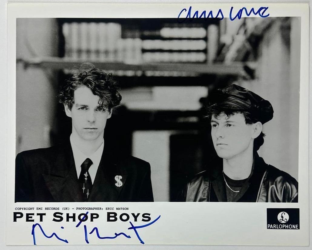 Pet Shop Boys Fully Group Signed 8" x 10" Promo Photo (2 Sigs) (JSA): Black-and-white 8" x 10" promotional photo signed in blue felt tip marker by Pet Shop Boys band members Chris Lowe and Neil Tennant. In fine condition. Authenticated by JSA. Provenance This piece was