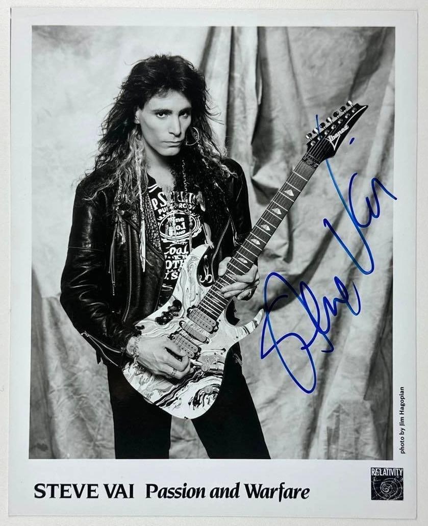 Steve Vai Signed 10" x 8" "Passion & Warfare" Promo Photo (JSA Authentication): Black-and-white 10" x 8" "Passion and Warfare" promotional photo signed in blue felt tip marker by musician Steve Vai. In fine condition. Authenticated by JSA. Provenance This piece was recently