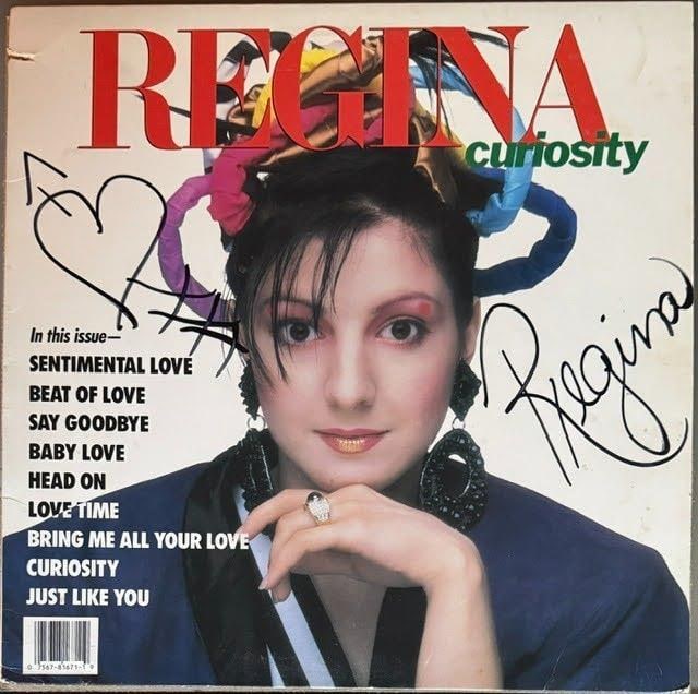 Regina Signed "Curiosity" Album (Third Party Guaranteed): "Curiosity" album signed on the cover in black felt tip marker by musician Regina, with a heart inscription. Measuring approximately 12" x 12" and in good condition with light general wear. Record is
