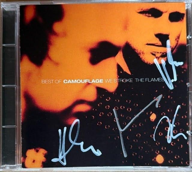 Camouflage Fully Group Signed "We Stroke the Flames" CD (4 Sigs) (Third Party Guaranteed): "Best of Camouflage – We Stroke the Flames" CD signed on the cover in white felt tip marker by Camoflage band members Heiko Mile, Marcus Meyn, Oliver Krevssia, and martin Kahling. Measuring