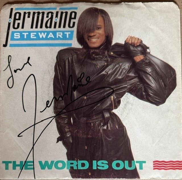 Jermaine Stewart Signed "The Word Is Out" 45 (JSA Authentication): "The Word Is Out" 45 signed on the cover in black felt tip marker by musician Jermaine Stewart, who inscribed "love" before his signature. Measuring approximately 7" x 7", the sleeve is in good condit