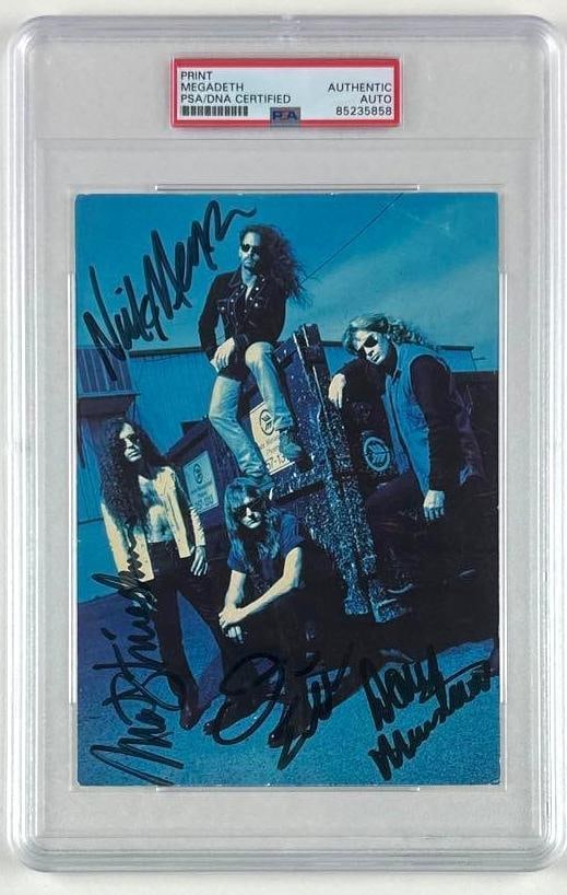 Megadeath Group Signed 7" x 5" Photo (PSA/DNA Encapsulated): Color 7" x 5" photo signed in black felt tip marker by Megadeath band members Dave Mustaine, Nick Menza, Dave Ellefson, and Marty Friedman. In fine condition. Encapsulated and authenticated by